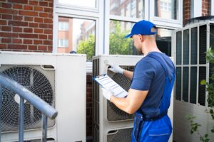 air-conditioning-tech-looking-at-outside-unit