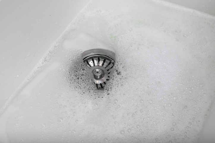 Clogged broken drain in the sink, standing water in the washbasin